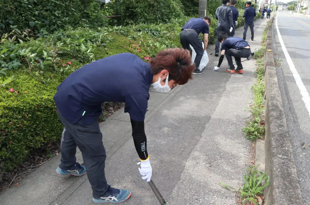 ゴミゼロ運動で歩道の清掃を行う社員の様子
